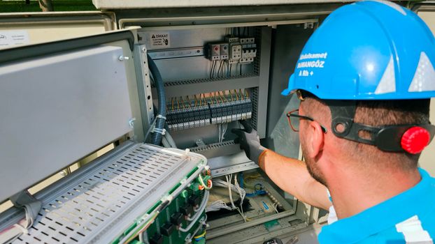 Services An electrician works on an outdoor fusebox, ensuring safety and functionality.